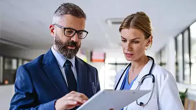 Doctor and Assistant Checking Reports